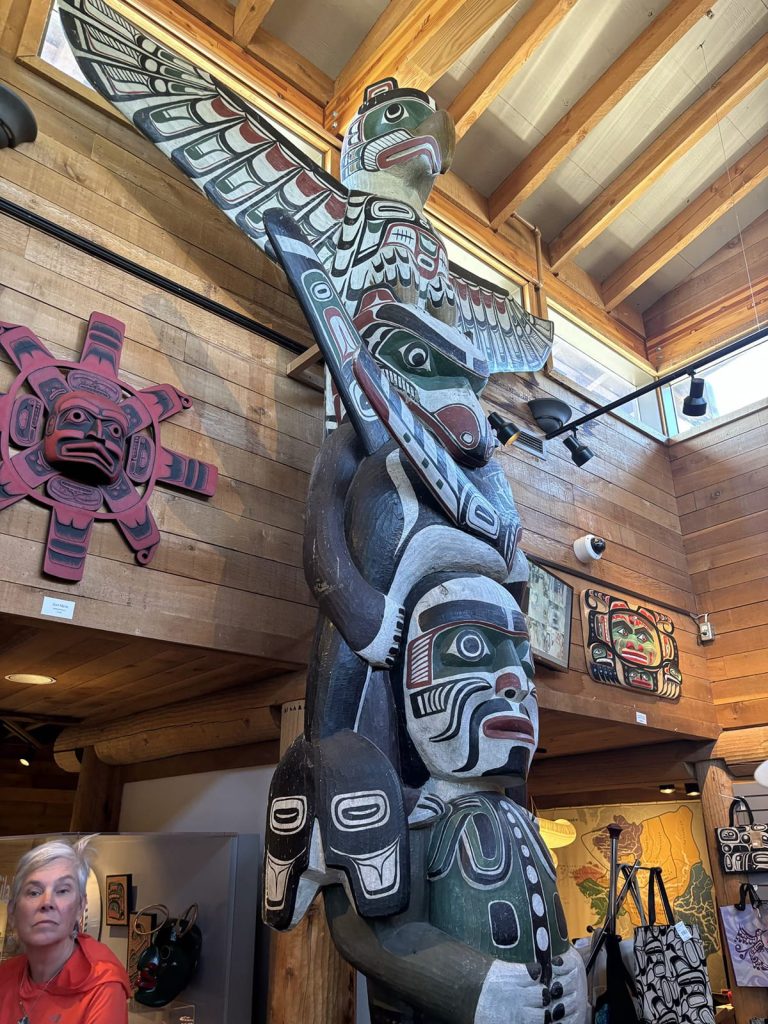 Bob Rein Reflections Off The Grid vibrant totem pole with animal carvings in museum setting